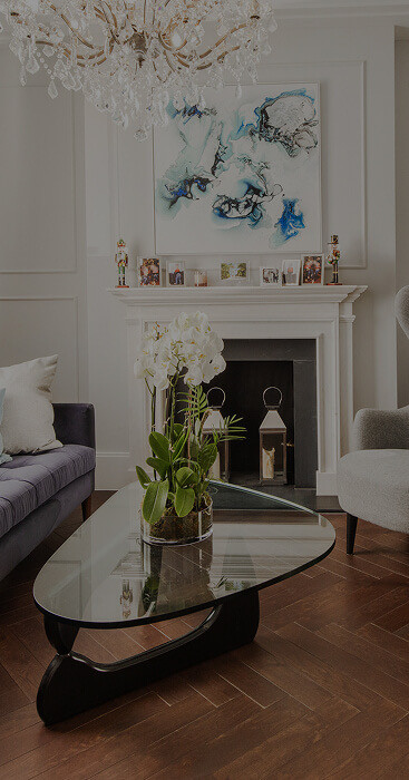 Refurbished period living room in London, designed and built by MVV, with a marble fireplace, crystal chandelier and herringbone oak floor