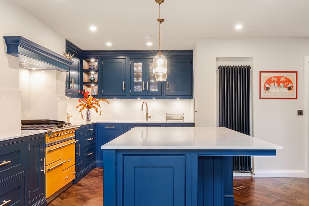 A blue kitchen with an island and a range cooker, in a rear extension in Blackheath.